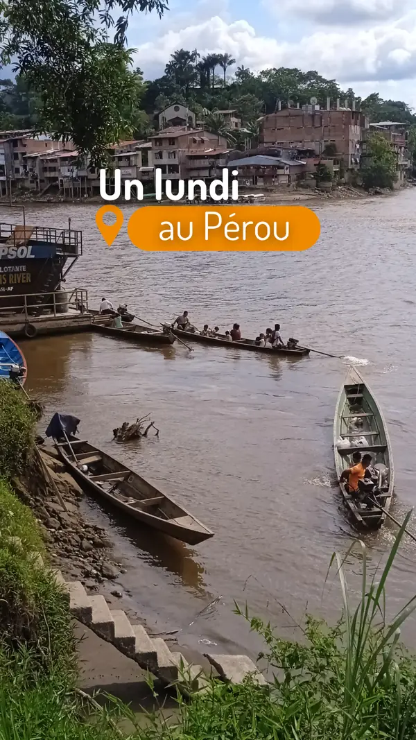Story « Un lundi au Pérou » : pirogues sur un fleuve devant une ville au bord de l’eau